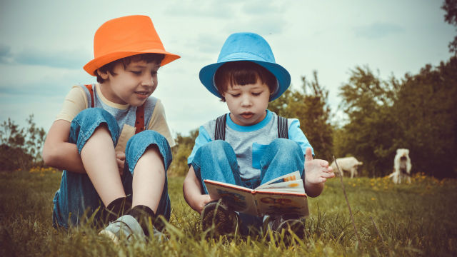due bambini leggono la bibbia insieme