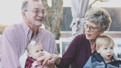 nonno e nonna con i bambini giocano nel giardino.