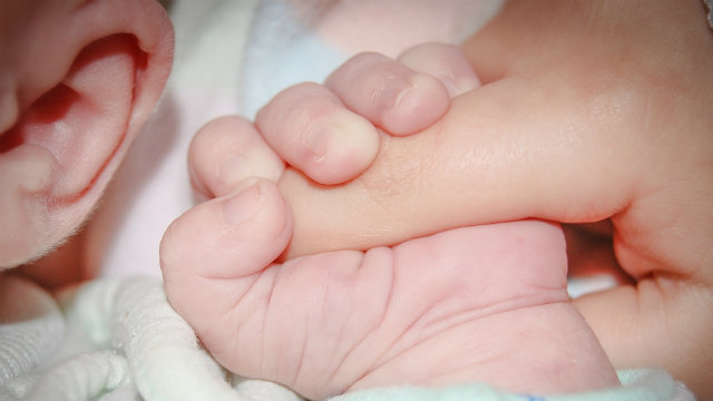 Il piccolo bambino ascolta il suono con le sue orecchie